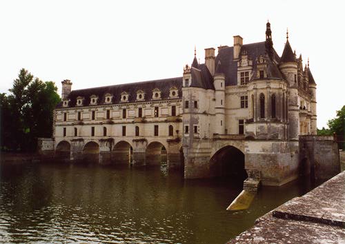 River flowing underneath big archways on which a big 
chateau is built